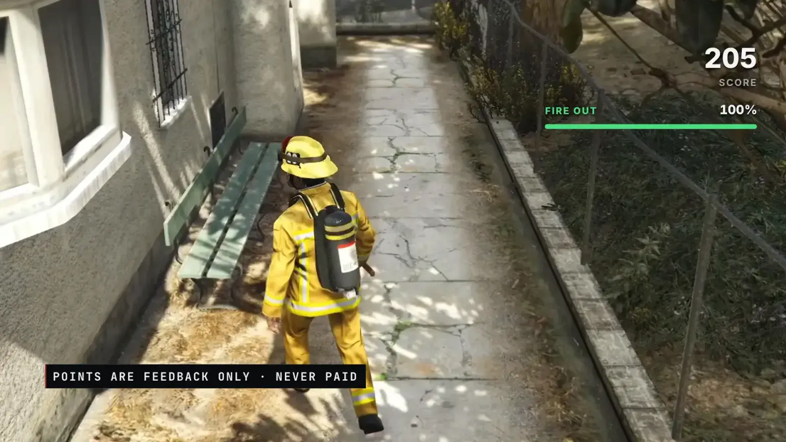 A firefighter walks down a side path after the last hot spot, with the fire card reading Fire out 100 % and 205